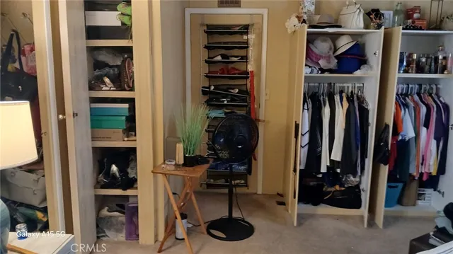 a view of walk in closet with clothes and shoes