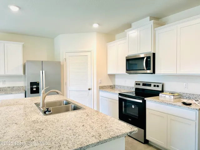 a kitchen with a sink a stove and cabinets