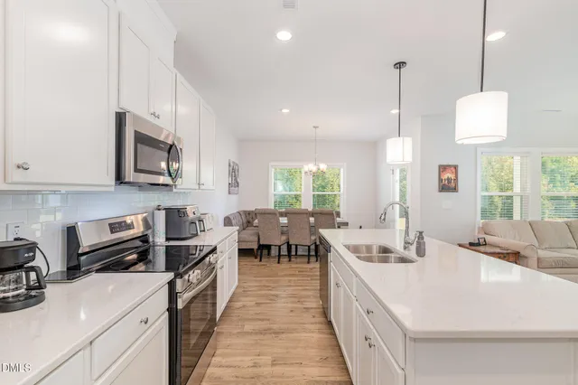 a open kitchen with stainless steel appliances granite countertop a sink a stove and a wooden floors