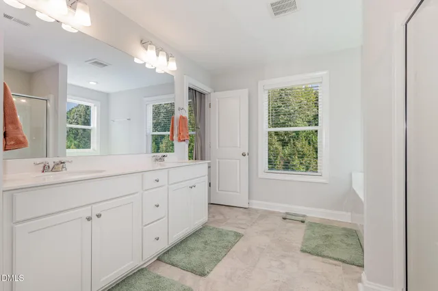 a spacious bathroom with double sink and a mirror