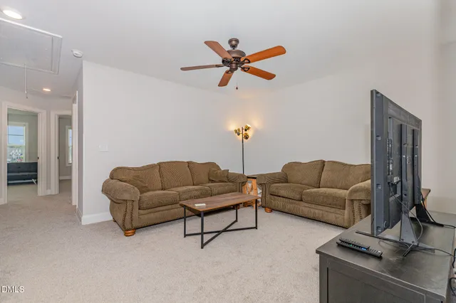 a living room with furniture and a ceiling fan