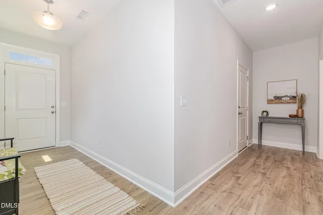 a view of a room with wooden floor and a bathroom