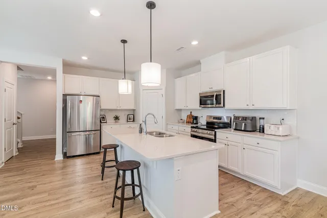 a kitchen with white cabinets and stainless steel appliances