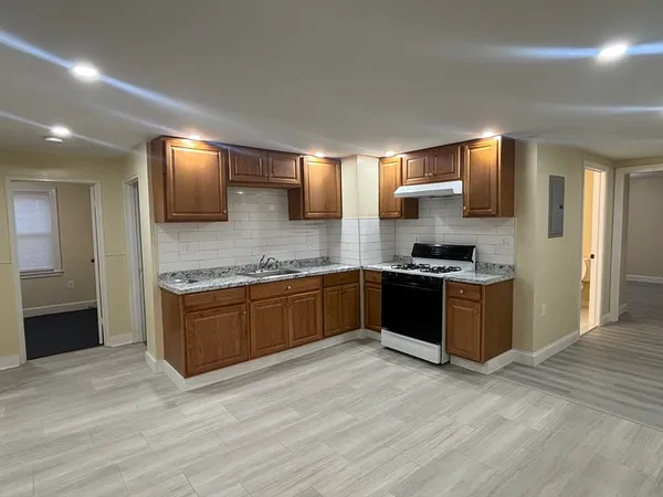 a large kitchen with kitchen island granite countertop a sink and cabinets