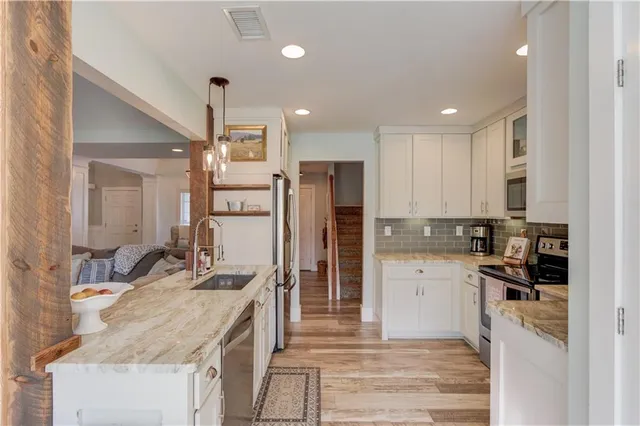 a kitchen with granite countertop a refrigerator stove and sink