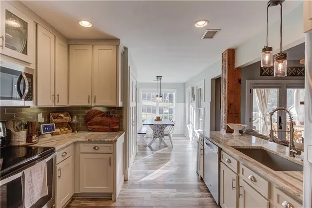 a kitchen with stainless steel appliances granite countertop a sink stove and cabinets