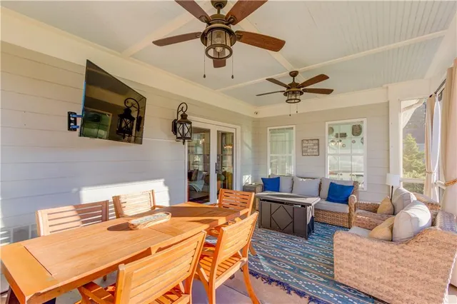 a living room with furniture a ceiling fan and a large window