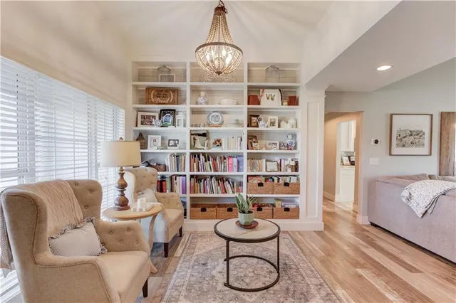 a living room with furniture a rug and a book shelf