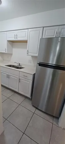 a kitchen with a refrigerator and cabinets