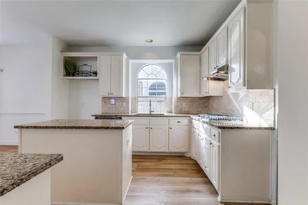 a kitchen with granite countertop a sink and a stove