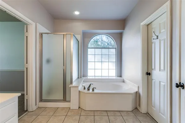 a bathroom with a tub a rug door and a window