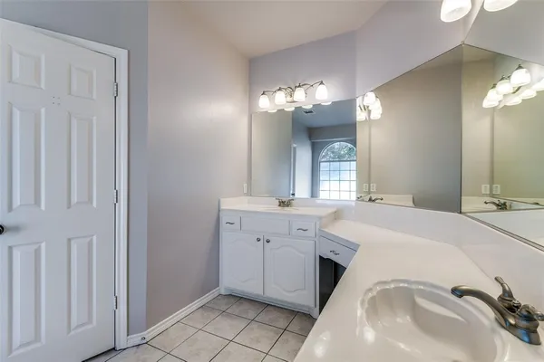 a spacious bathroom with a sink and a mirror