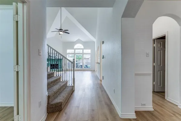a view of a hallway with wooden floor and staircase