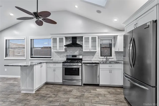 a kitchen with stainless steel appliances granite countertop a stove sink microwave and refrigerator