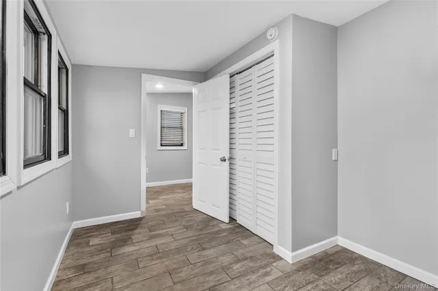 an empty room with windows and stainless steel appliances