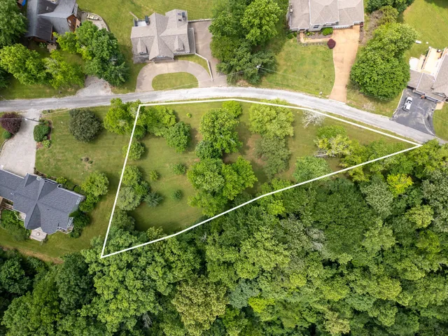 an aerial view of a residential houses with yard