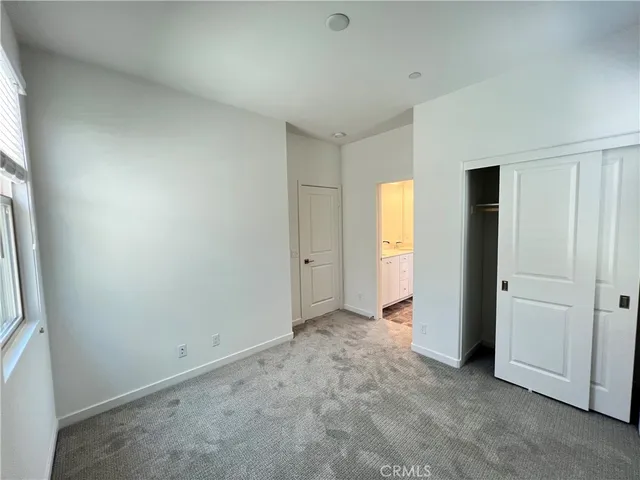 an empty room with closet and windows