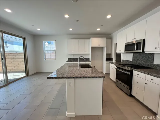 a kitchen with stainless steel appliances granite countertop a sink and a stove