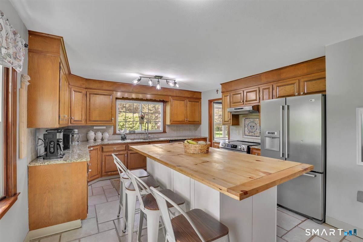 72 Old Post Road Wethersfield, CT 06109 - Photo 7 of 40 a kitchen with a table chairs refrigerator and cabinets