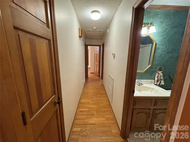 a view of a hallway with wooden floor and staircase