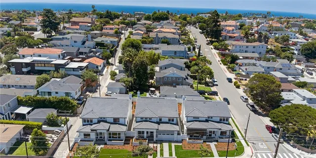 an aerial view of residential houses with yard and parking space