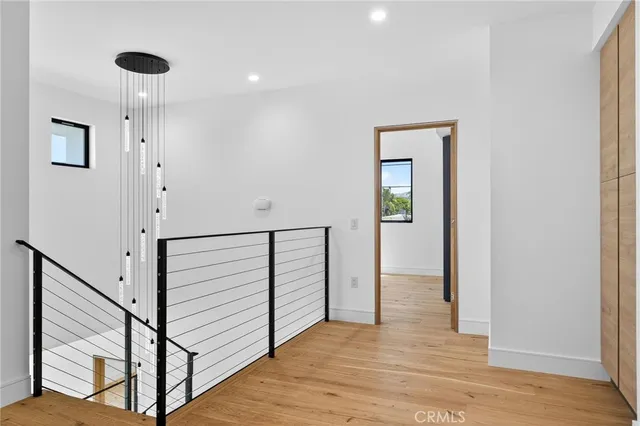 a view of a hallway with wooden floor and staircase