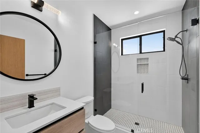 a bathroom with a sink mirror vanity and toilet
