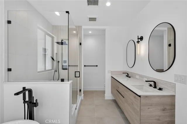a bathroom with a double vanity sink mirror and glass door