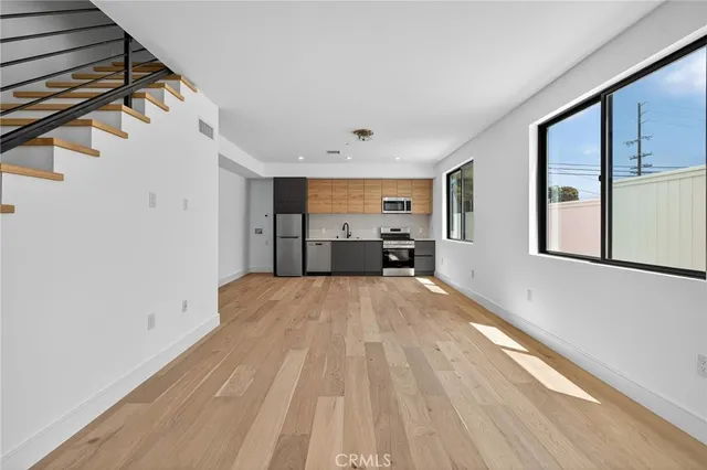 a view of empty room with wooden floor and window