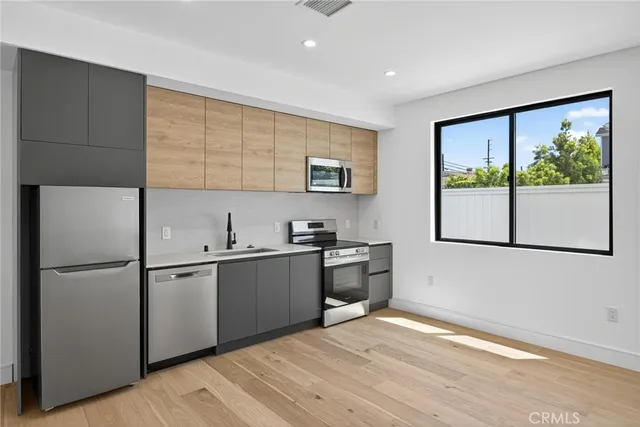 a kitchen with stainless steel appliances granite countertop a refrigerator and a sink