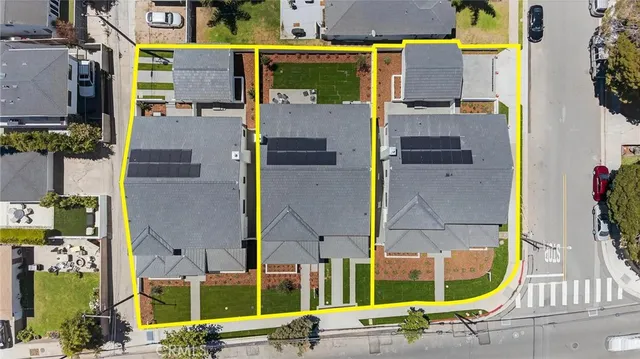 an aerial view of houses with a street