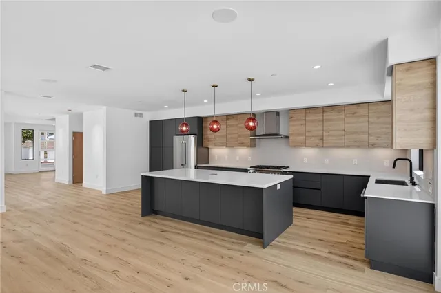 a large kitchen with stainless steel appliances granite countertop a sink and cabinets