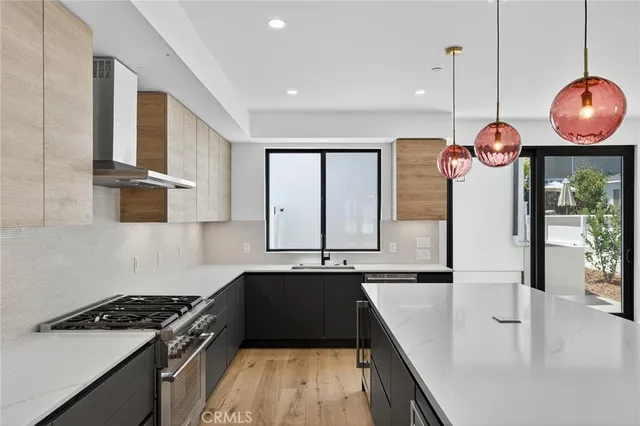 a kitchen with granite countertop a stove a sink and a refrigerator