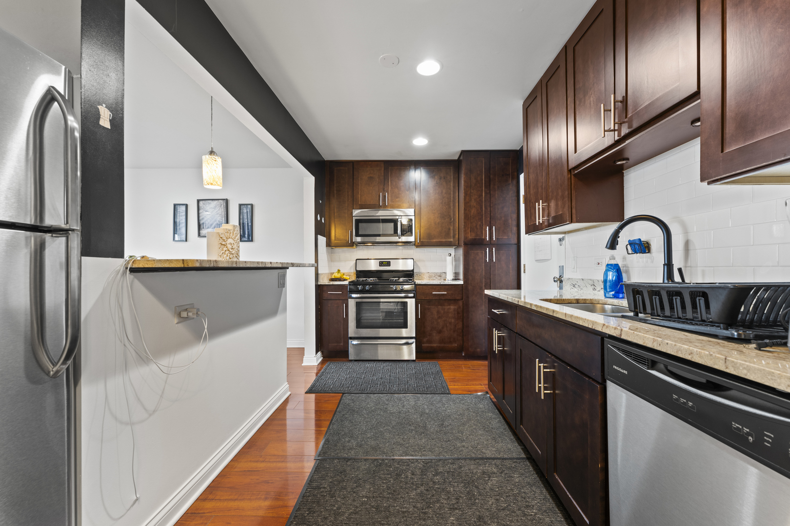 4623 North Chester Avenue, Unit 410 Chicago, IL 60656 - Photo 6 of 20 a kitchen with stainless steel appliances granite countertop a refrigerator a sink and a stove