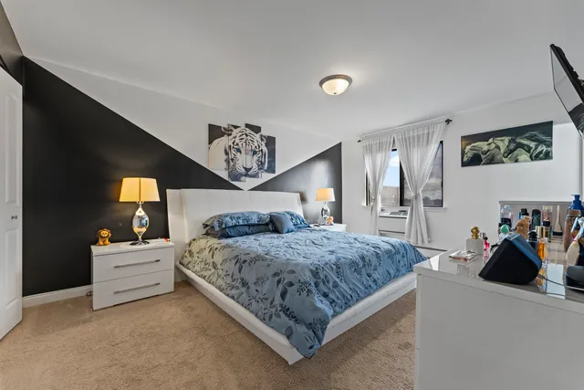 a bedroom with a bed and dresser with mirror