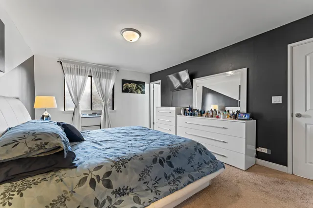 a bedroom with a large bed and a dresser