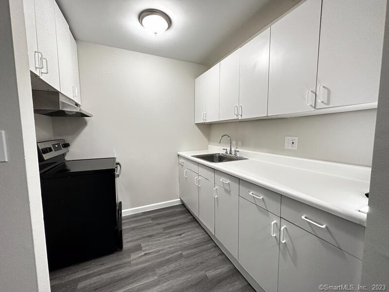 a kitchen with cabinets and wooden floor