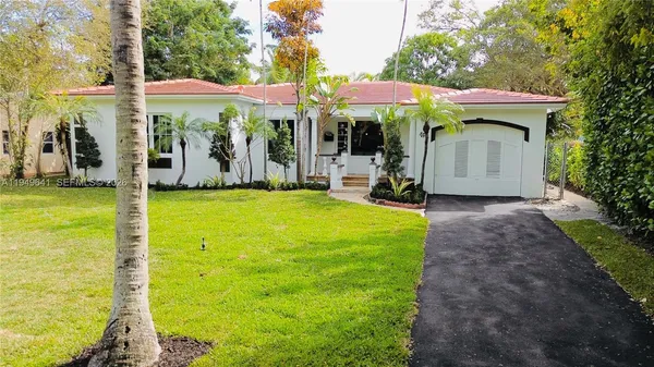 a view of a patio with chairs and table under an umbrella