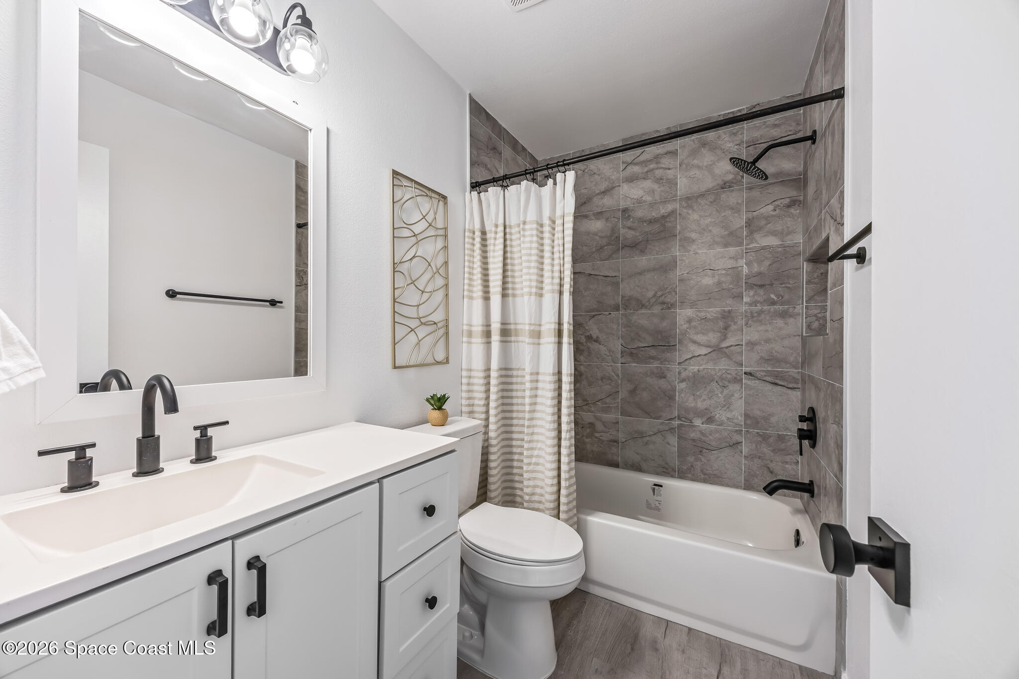1411 Sheafe Avenue Northeast, Unit 101 Palm Bay, FL 32905 - Photo 16 of 24 a bathroom with a sink toilet and shower