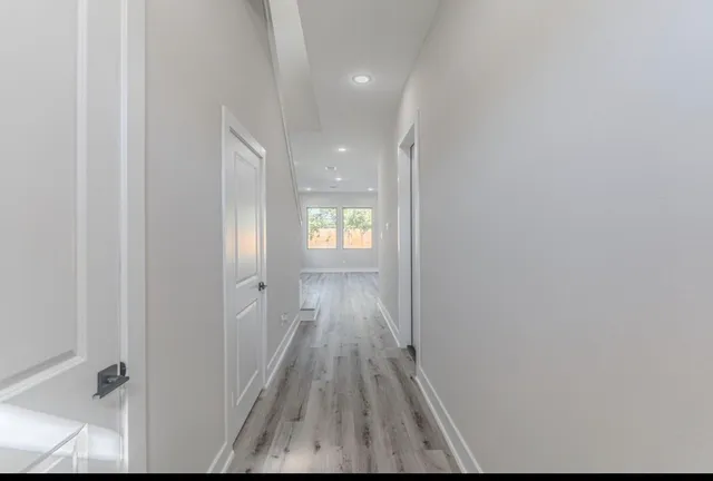 a view of a hallway with wooden floor and closet