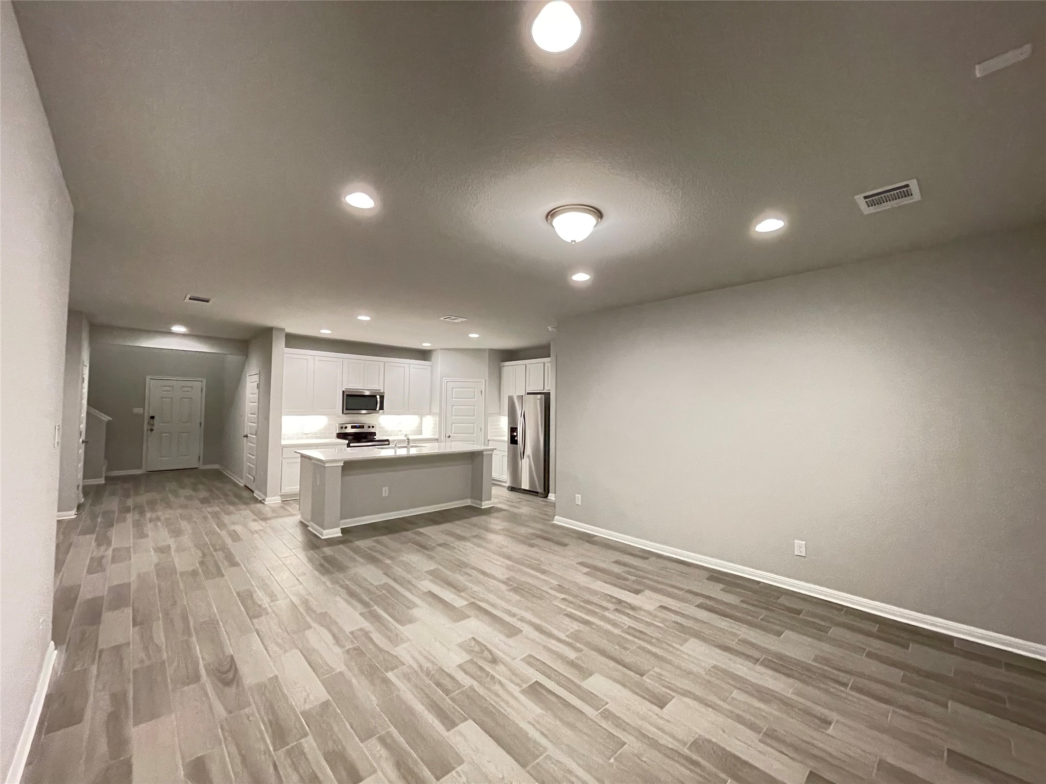 316 Mclintock Road Jarrell, TX 76537 - Photo 10 of 40 a large white kitchen with kitchen island a sink stainless steel appliances and cabinets
