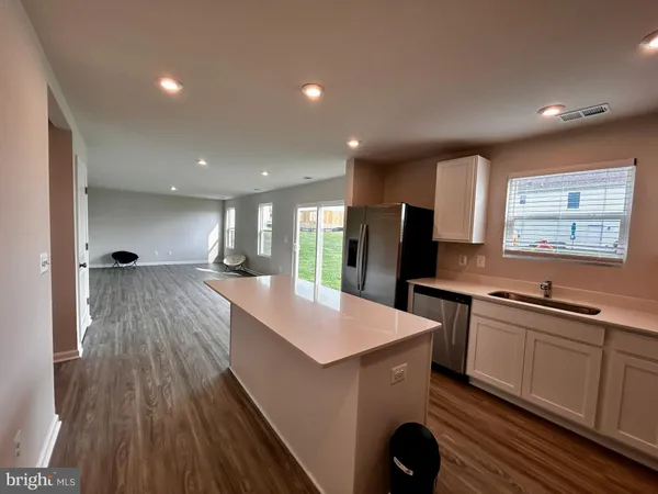a kitchen with stainless steel appliances granite countertop a sink dishwasher and a stove with wooden floor