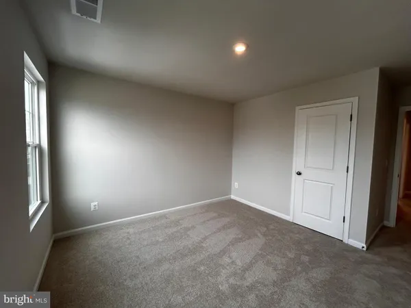 an empty room with windows and closet