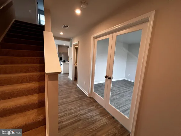 a view of a hallway with wooden floor and staircase