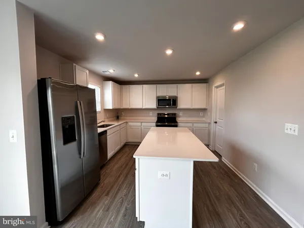 a kitchen with refrigerator cabinets and wooden floor