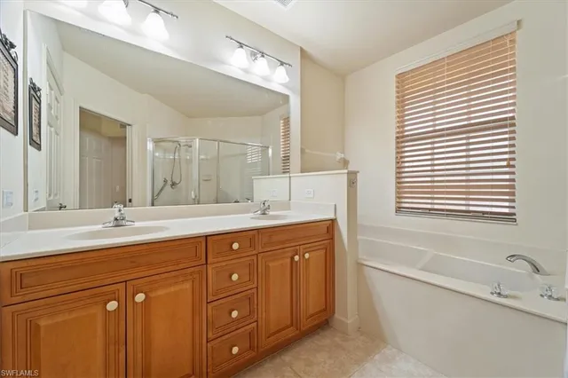 a bathroom with a granite countertop sink mirror and a bathtub