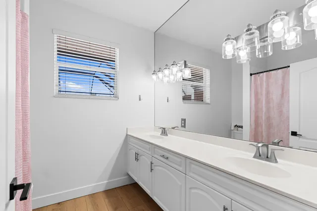 a bathroom with a double vanity sink and a mirror