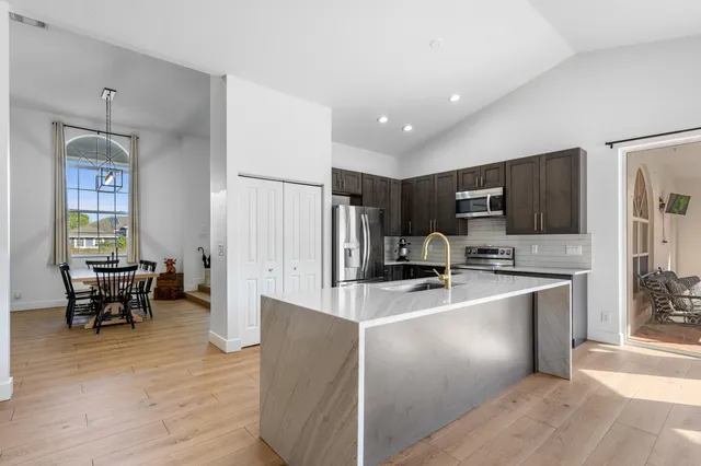 a kitchen with stainless steel appliances granite countertop a sink stove and refrigerator
