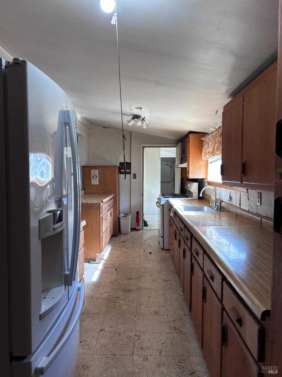 1005 Poplar Road Vacaville, CA 95687 - Photo 13 of 17 a large kitchen with stainless steel appliances a sink a counter space and a refrigerator