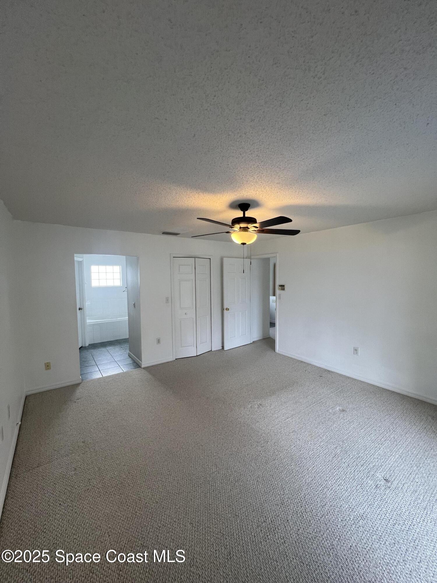 1213 Old Millpond Road Melbourne, FL 32940 - Photo 11 of 20 a view of an empty room and a ceiling fan